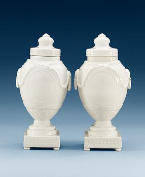 A pair of white glazed Berlin jars and covers, circa 1900.