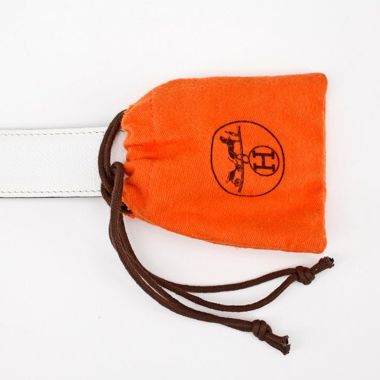 HERMÈS, a reversible belt, white and black with gold colored H belt buckle.