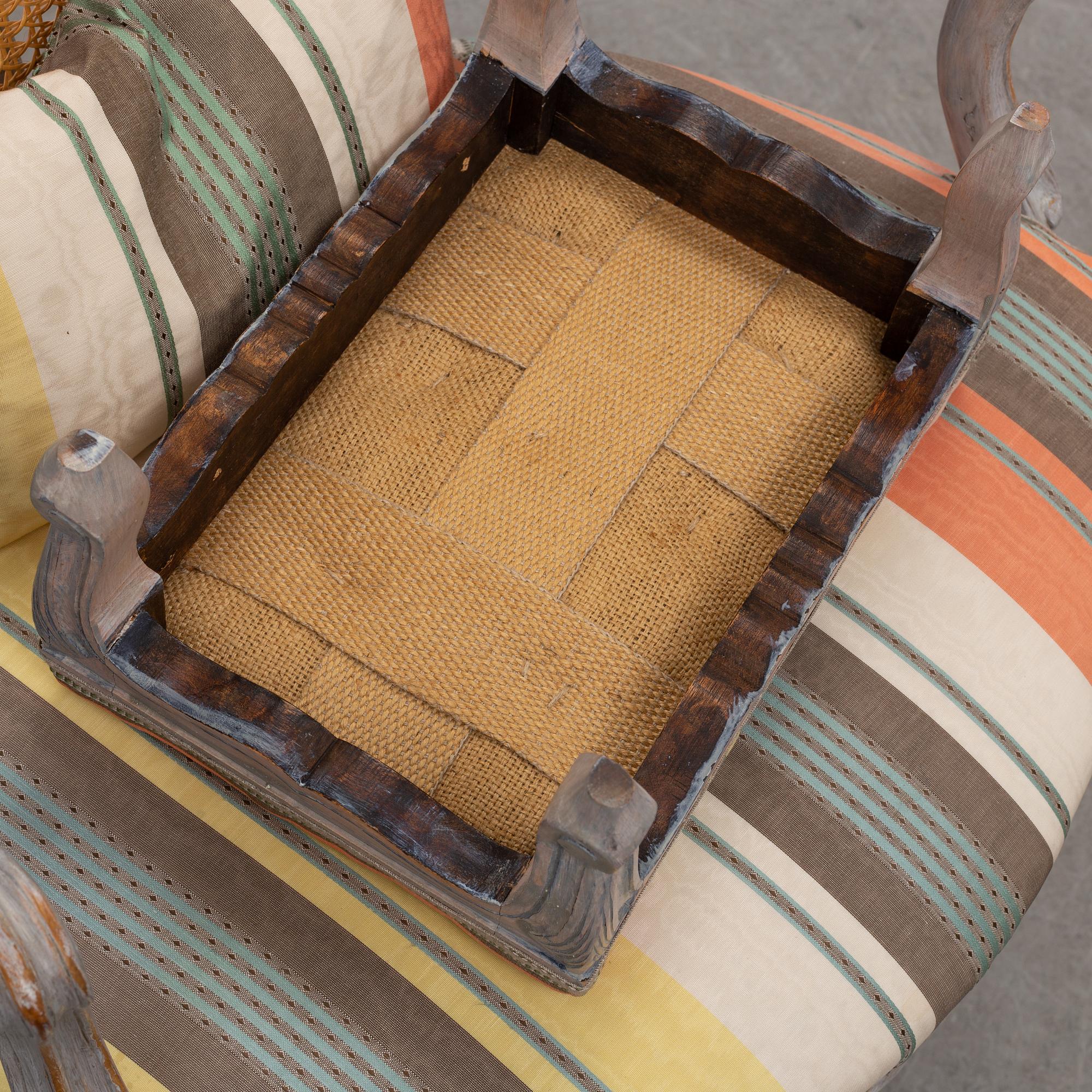 A later part of the 19th century rococo style armchair and second half of the 20th century stool.