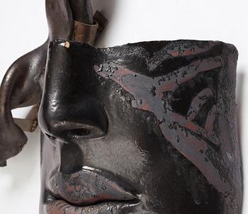 Hertha Hillfon, a black glazed stoneware wall sculpture in two parts of a face and a sky, executed in her own studio, Stockholm 1960s.