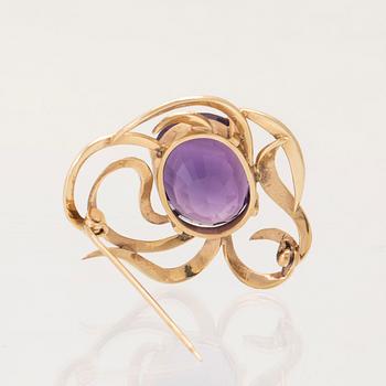 An 18K gold brooch set with an oval faceted amethyst.