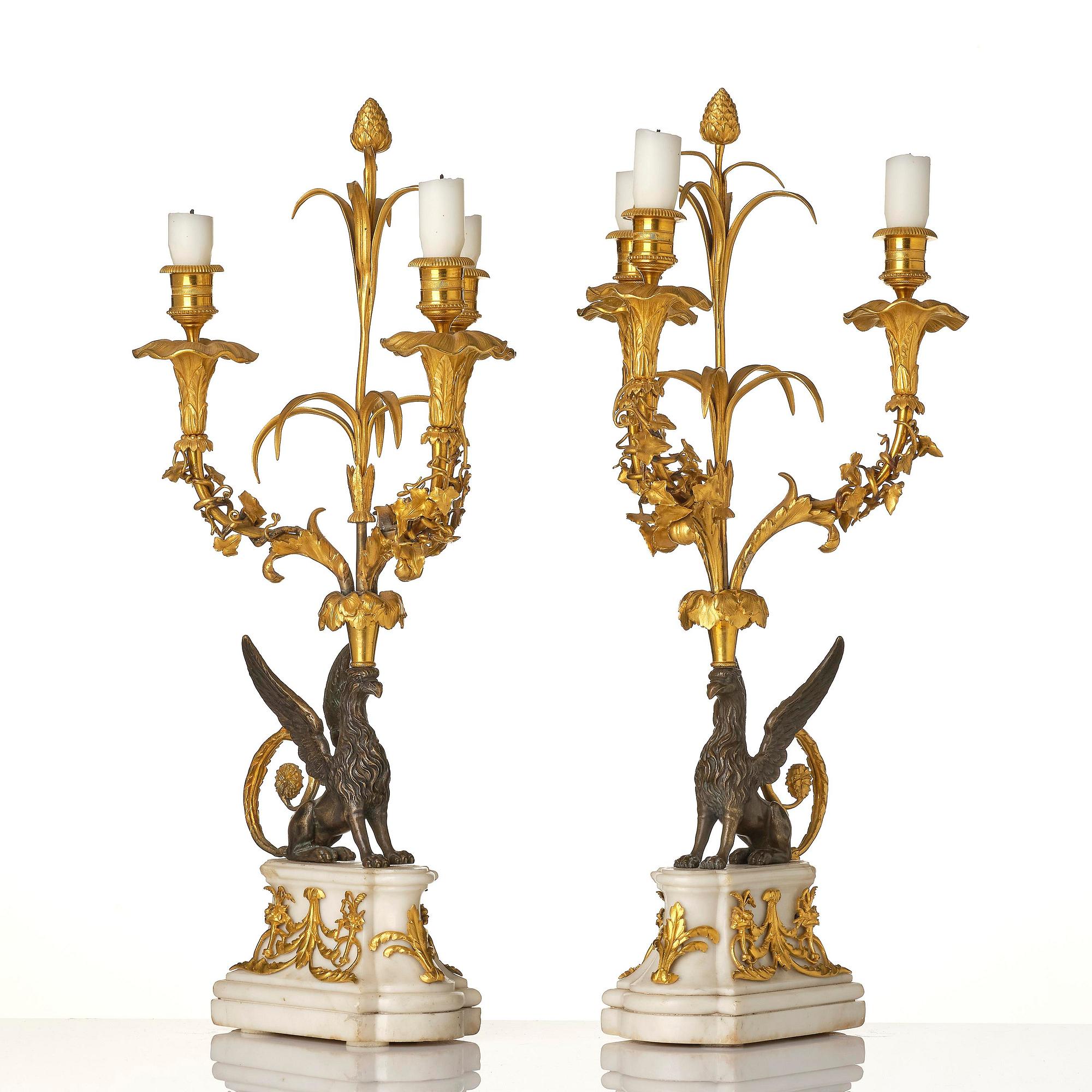 A pair of three-light Louis XVI patinated and ormolu candelabra in the manner of François Rémond, late 18th century.