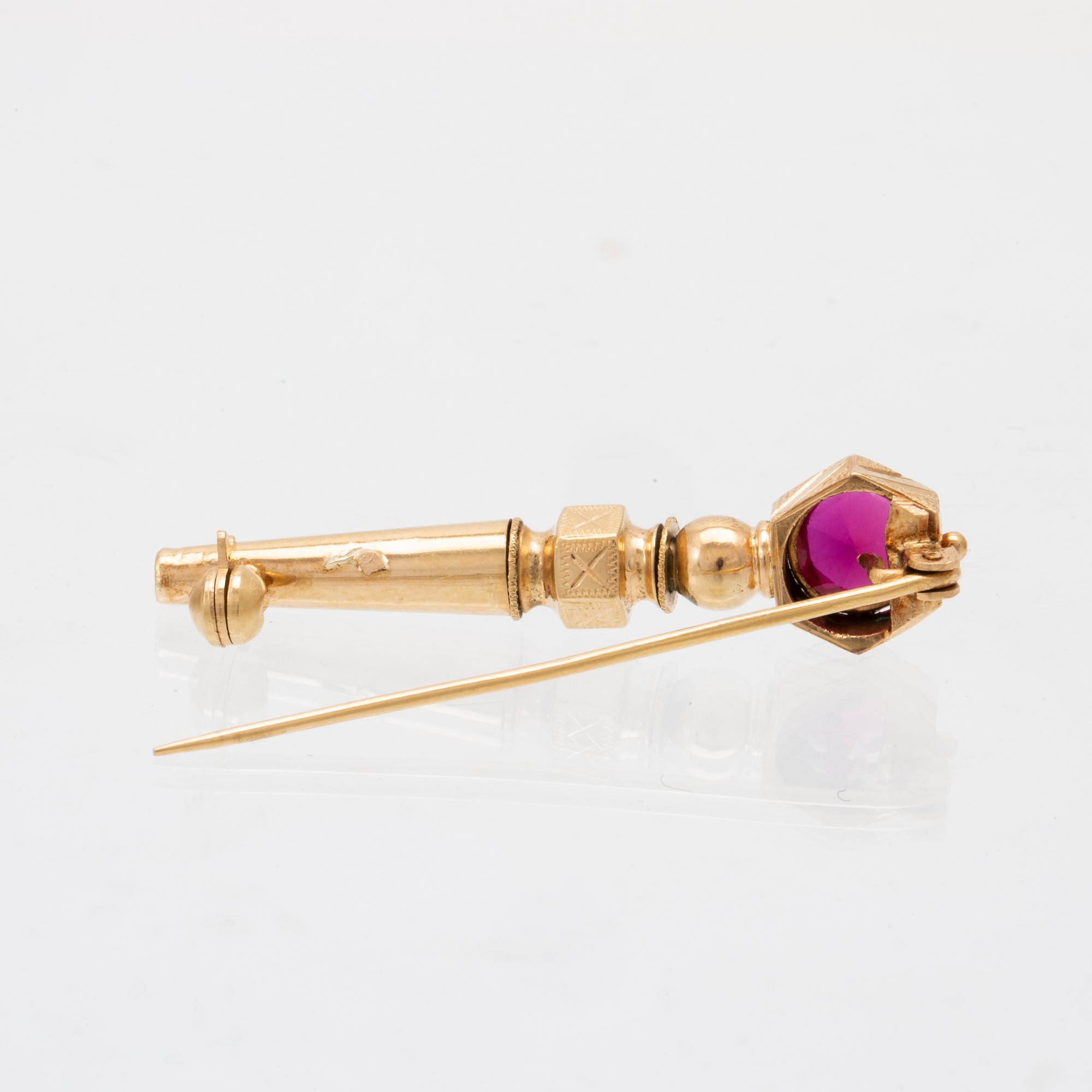 An 18K gold brooch set with a synthetic ruby.