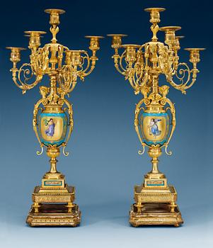 1328. A pair of seven-light gilt bronze chandelabras with porcelain settings, 19th Century, presumably Russian.