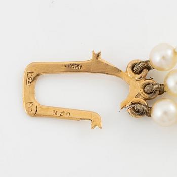 Bracelet, three-stranded with graduated cultured pearls, clasp 18K gold set with octagonal-cut diamonds.