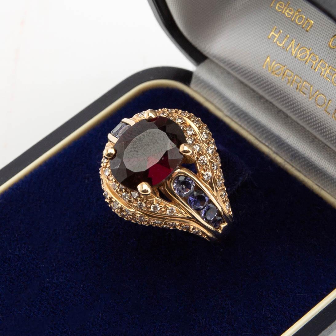 Ring, 18K gold with garnet, lavender-coloured iolites and brilliant-cut diamonds.