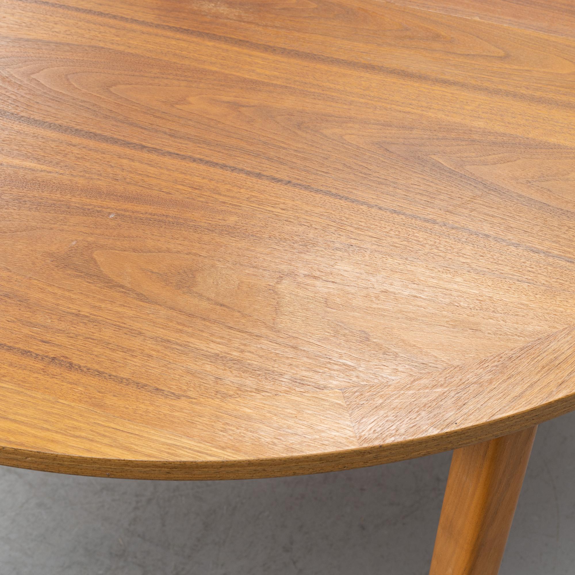 A round walnut veneered dining table.