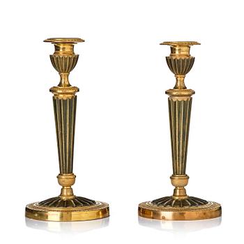 154. A pair of French Empire ormolu and patinated bronze candlesticks, early 19th century.