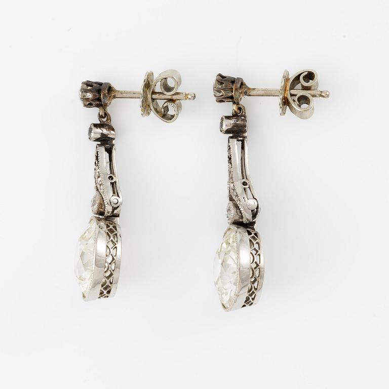 A pair of platinum earrings with two old-cut diamonds.