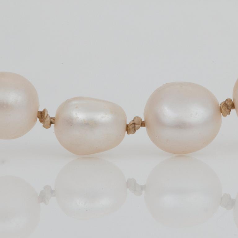 A natural graduated pearl necklace. Ø 2.6 - 10.3 mm. Clasp set with diamonds and rubies (one ruby synthetic).