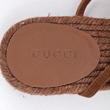 GUCCI, a pair of brown sandals.