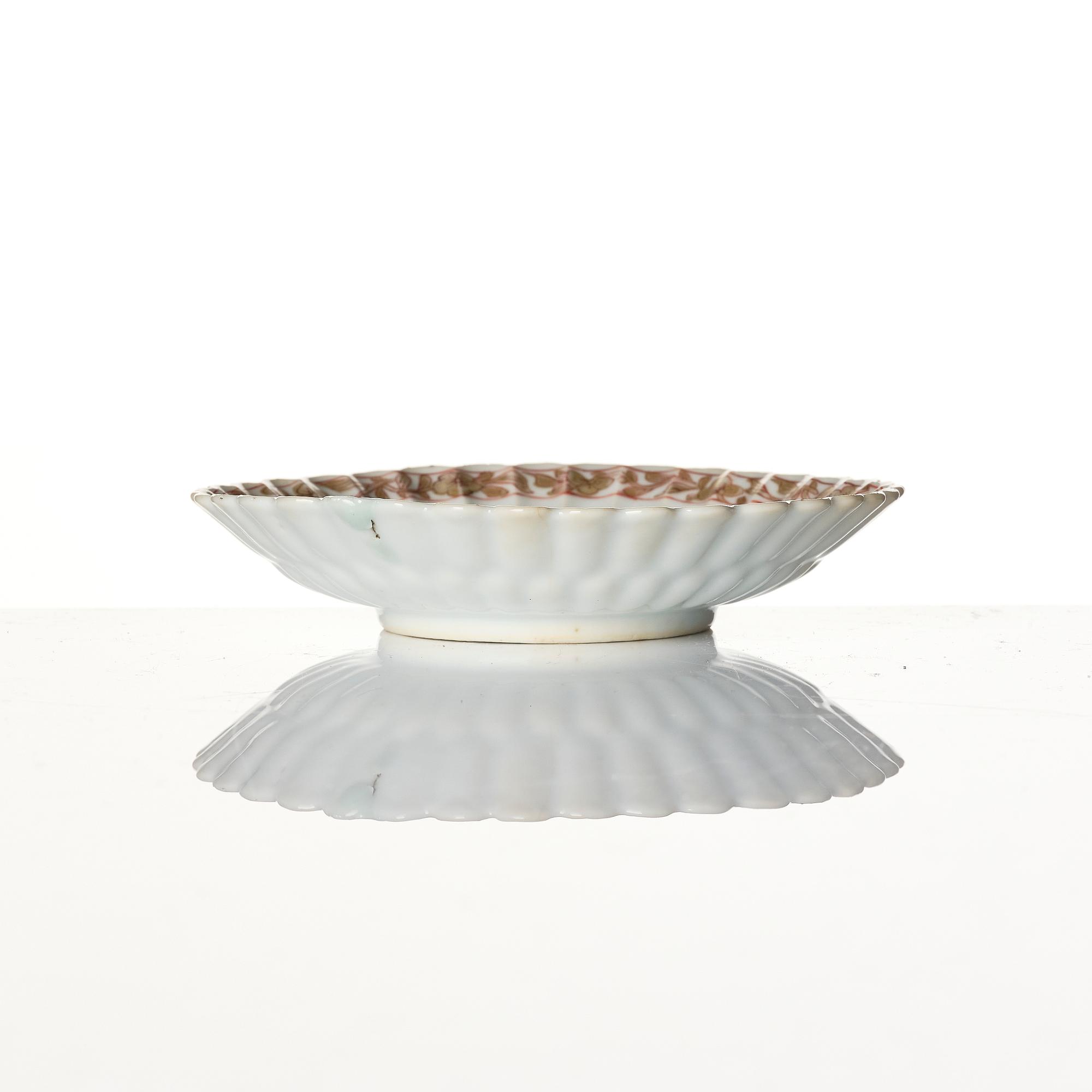 A Chinese iron red porcelain cup with saucer and a small famille verte dish, Qing dynasty, Kangxi (1662-1722).