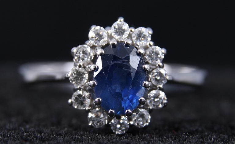 CARMOSERING, vitguld, 12 st briljanter samt safir. 1.01 ct enl inskription.
