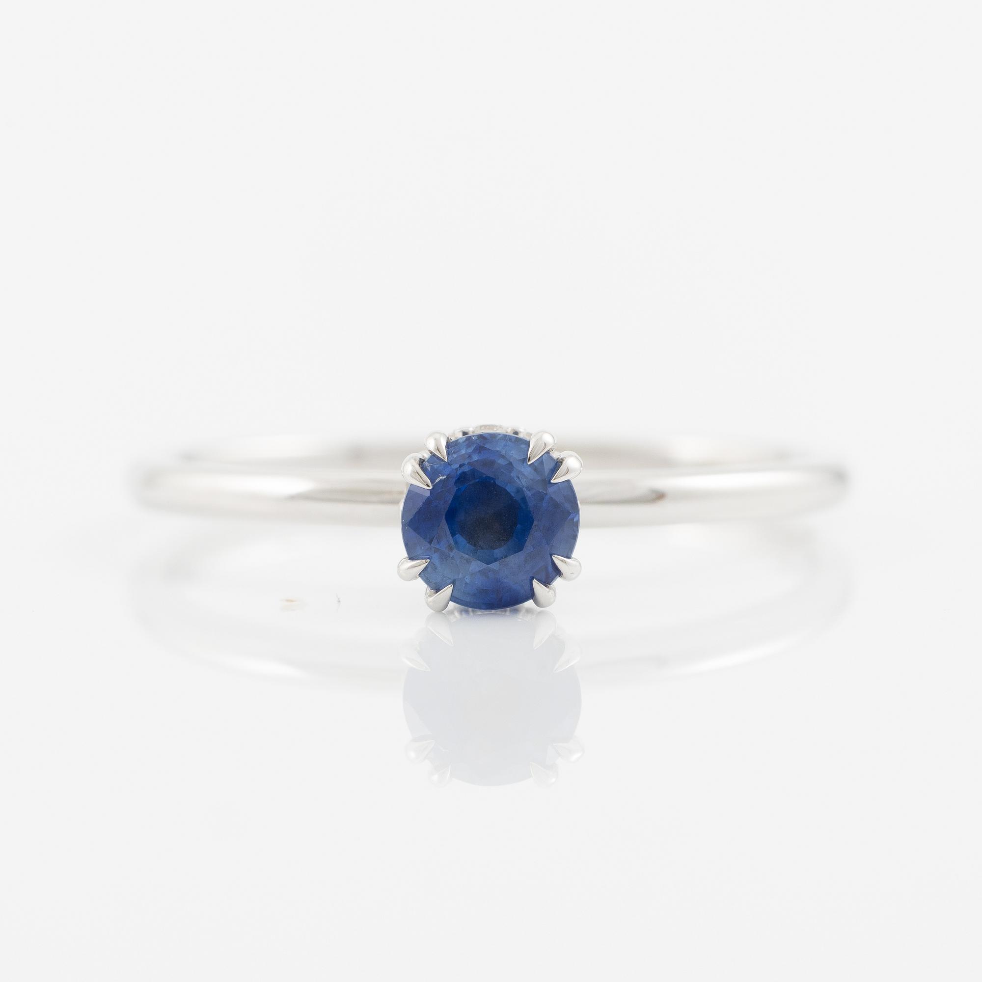 Ring 14K white gold with a sapphire and small brilliant-cut diamonds.