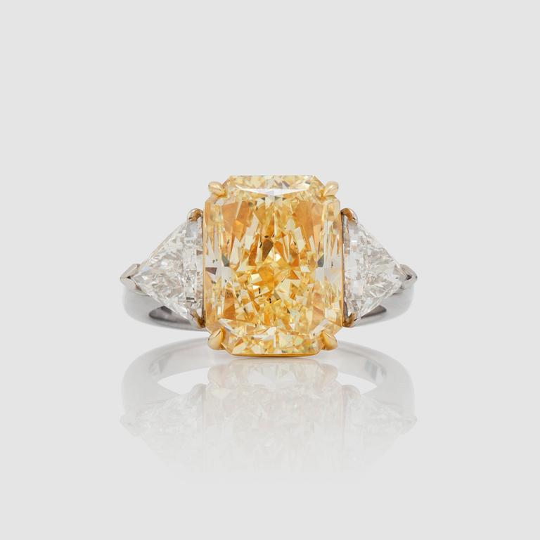 Ring med en fancy yellow diamant,  8.01 ct, FY/SI2, mixed cut, och  triangulärslipade diamanter, 1.62 ct totalt.