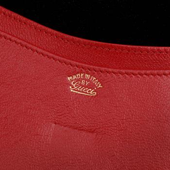 GUCCI, a black suede wallet with red leather lining.