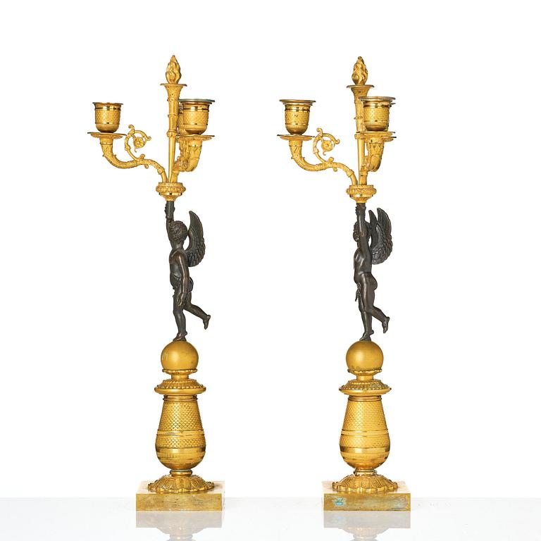 A pair of Empire three light ormolu and patinated bronze candelabra.