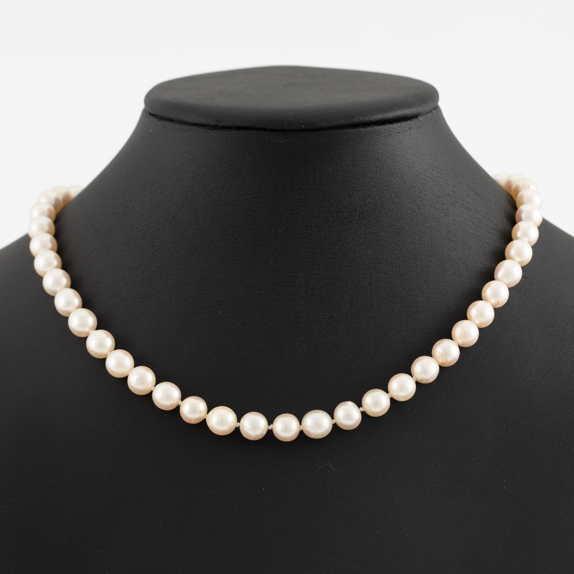 Necklace of cultured pearls, clasp in 18K gold set with eight-cut diamond and dividers with round brilliant-cut diamonds.