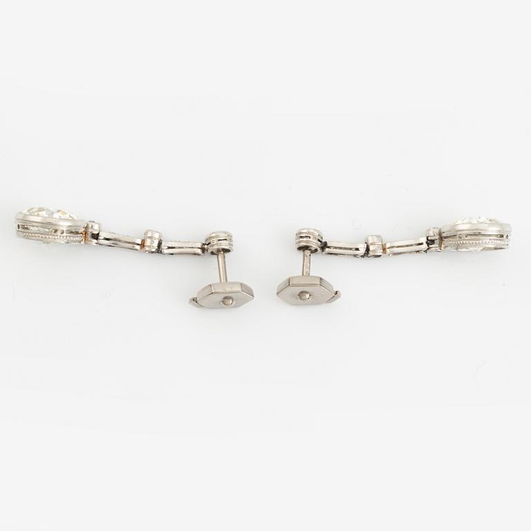 A pair of platinum earrings with two larger old-cut diamonds.