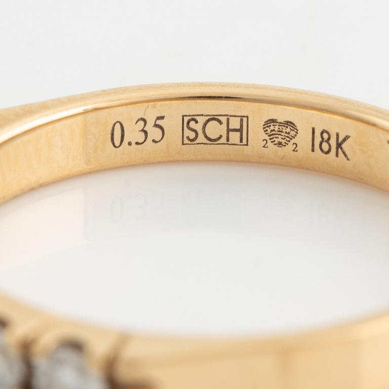An 18K gold ring set with round briliiant-cut diamonds.
