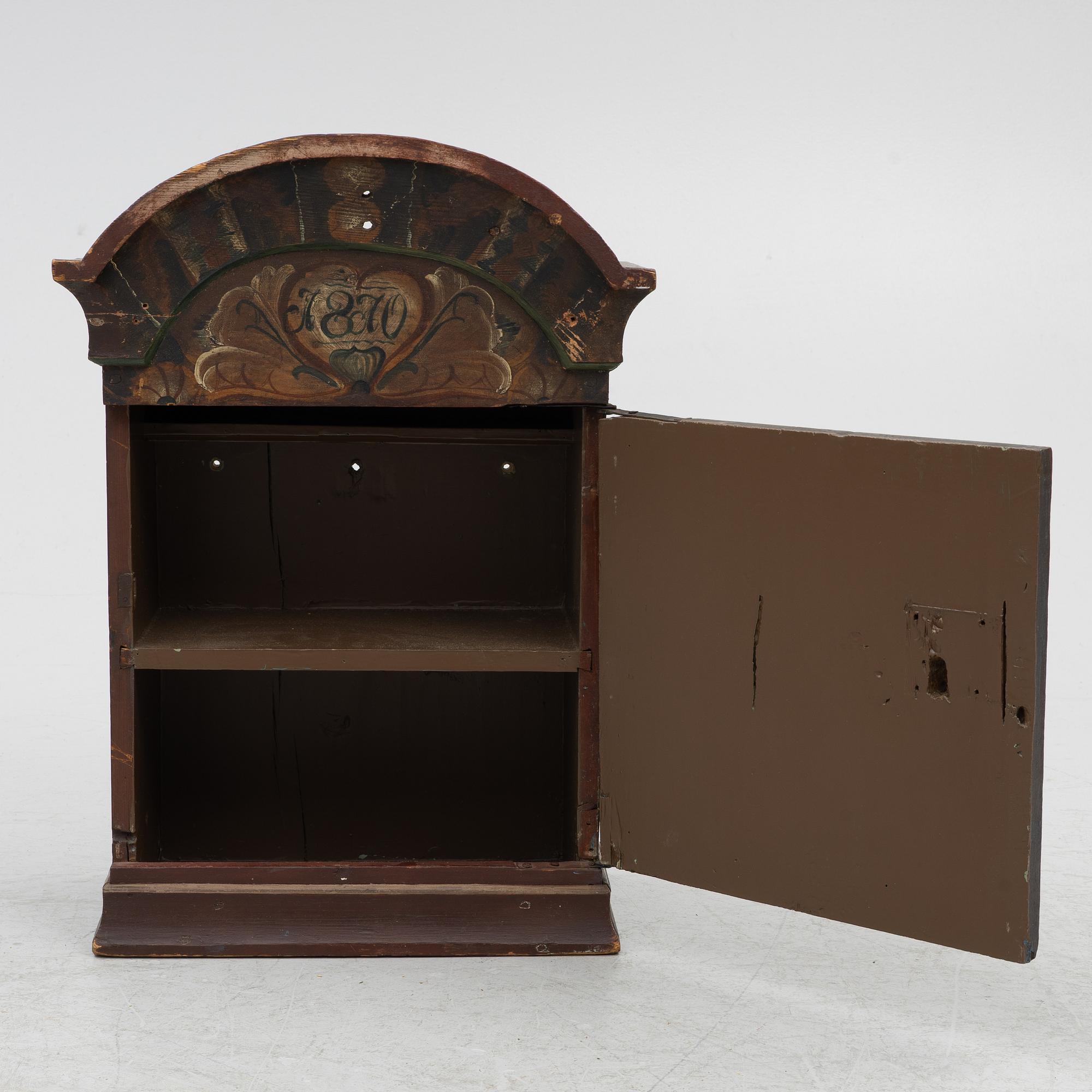 A hanging cabinet, dated 1870.