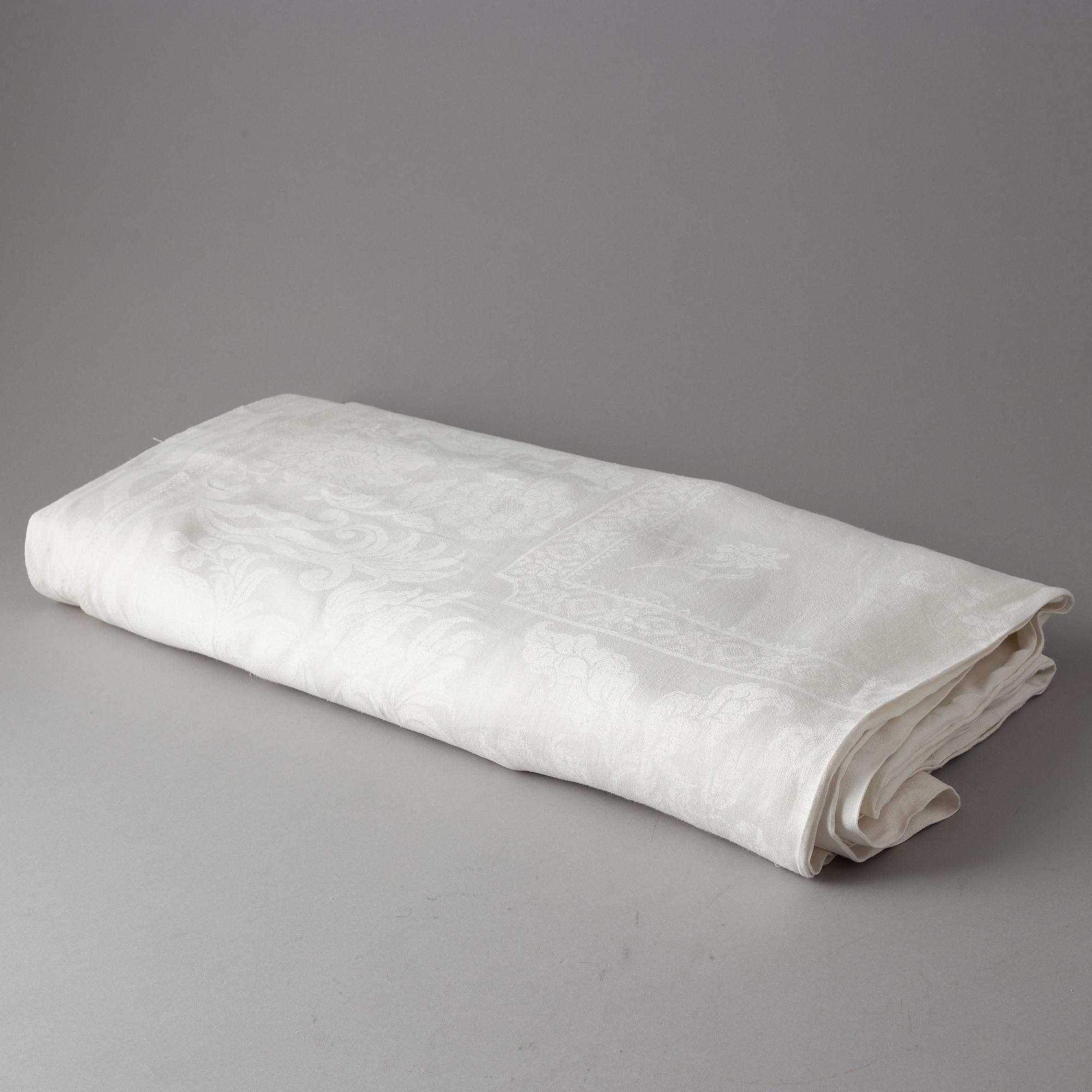 A tablecloth, linen damask, ca 680 x 212 cm. Conjugal coat of arms.
