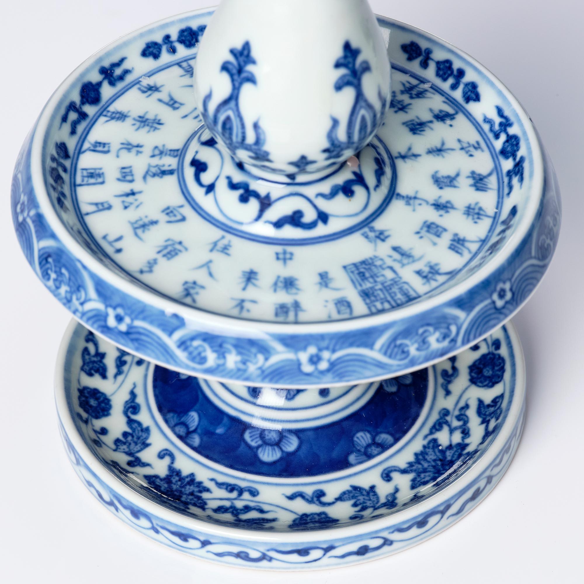 A pair of blue and white pricket candle sticks, with a poem, Qing dynasty with a Qianlong mark and of the period.