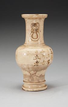 A cream glazed vase, Ming dynasty, with an inscription that dates it to 1608.