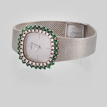 ARMBANDSUR, Omega, 18K vitguld med briljantslipade diamanter samt fasettslipade smaragder. Vikt 64,6 gram.
