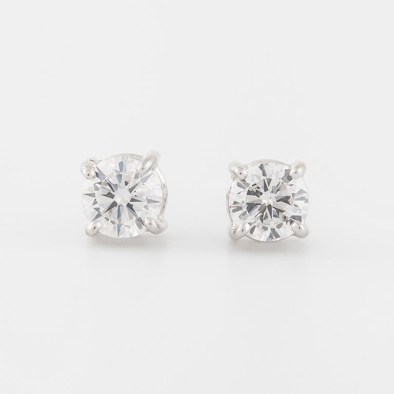 A pair of brilliant cut diamond earrings.