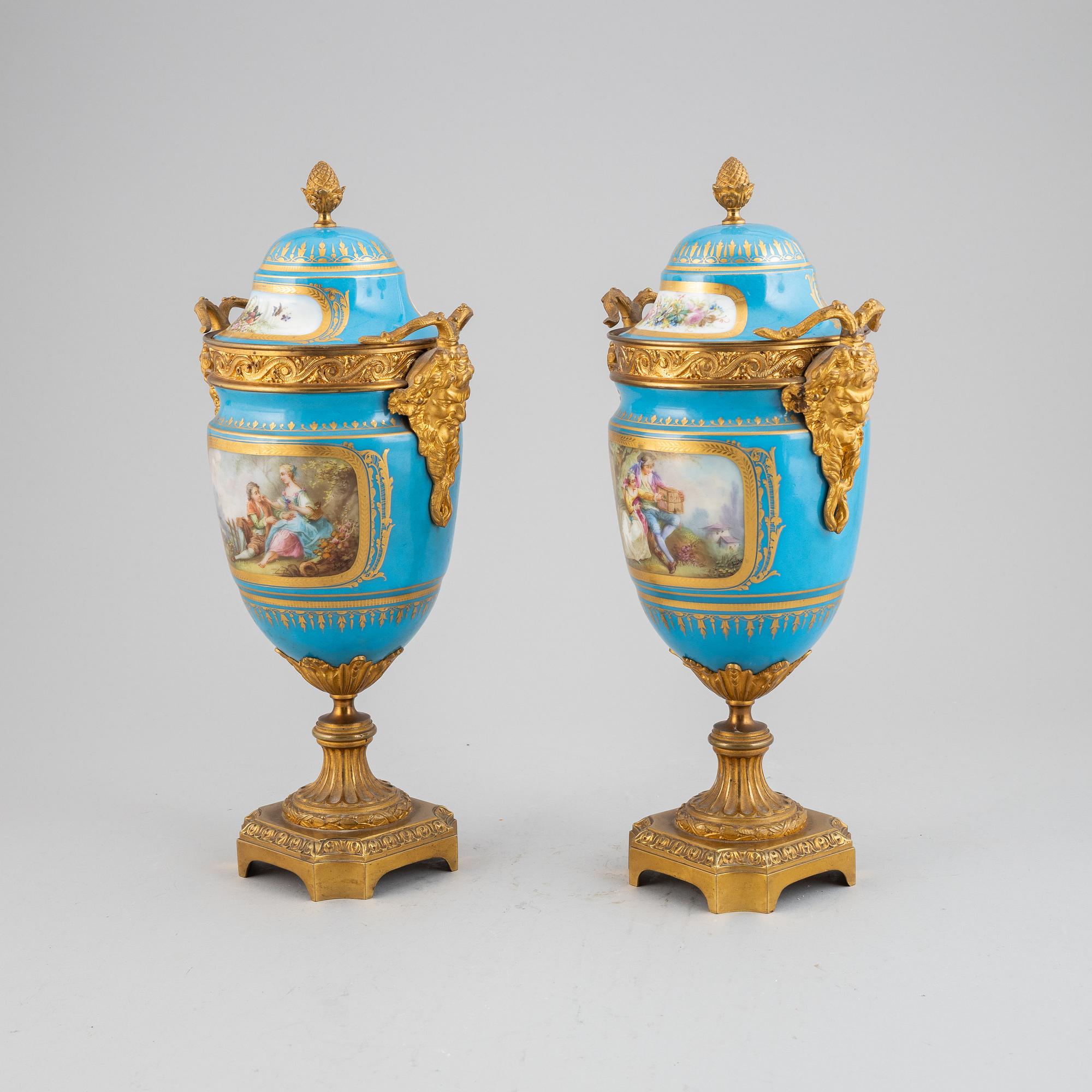 A pair of pordelain and gilt brass urns in teh style of Sevres, 20th Century.