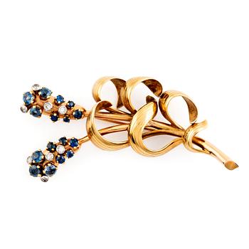 An 18K gold WA Bolin brooch set with faceted sapphires and eight-cut diamonds.
