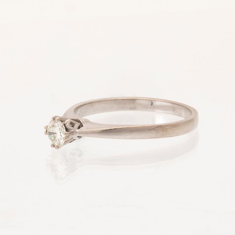 An 18K white gold solitaire ring set with a round brilliant-cut diamond.