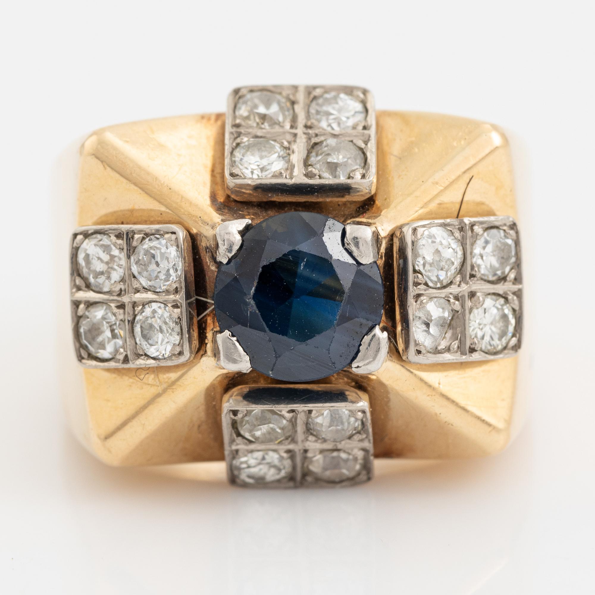 An 18K gold ring set with a faceted sapphire and diamonds.