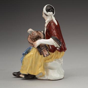 A porcelain figure of a begger playing an instrument, 1740's, presumably Meissen.