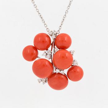 A cabochon-cut coral and brilliant cut diamond pendant.