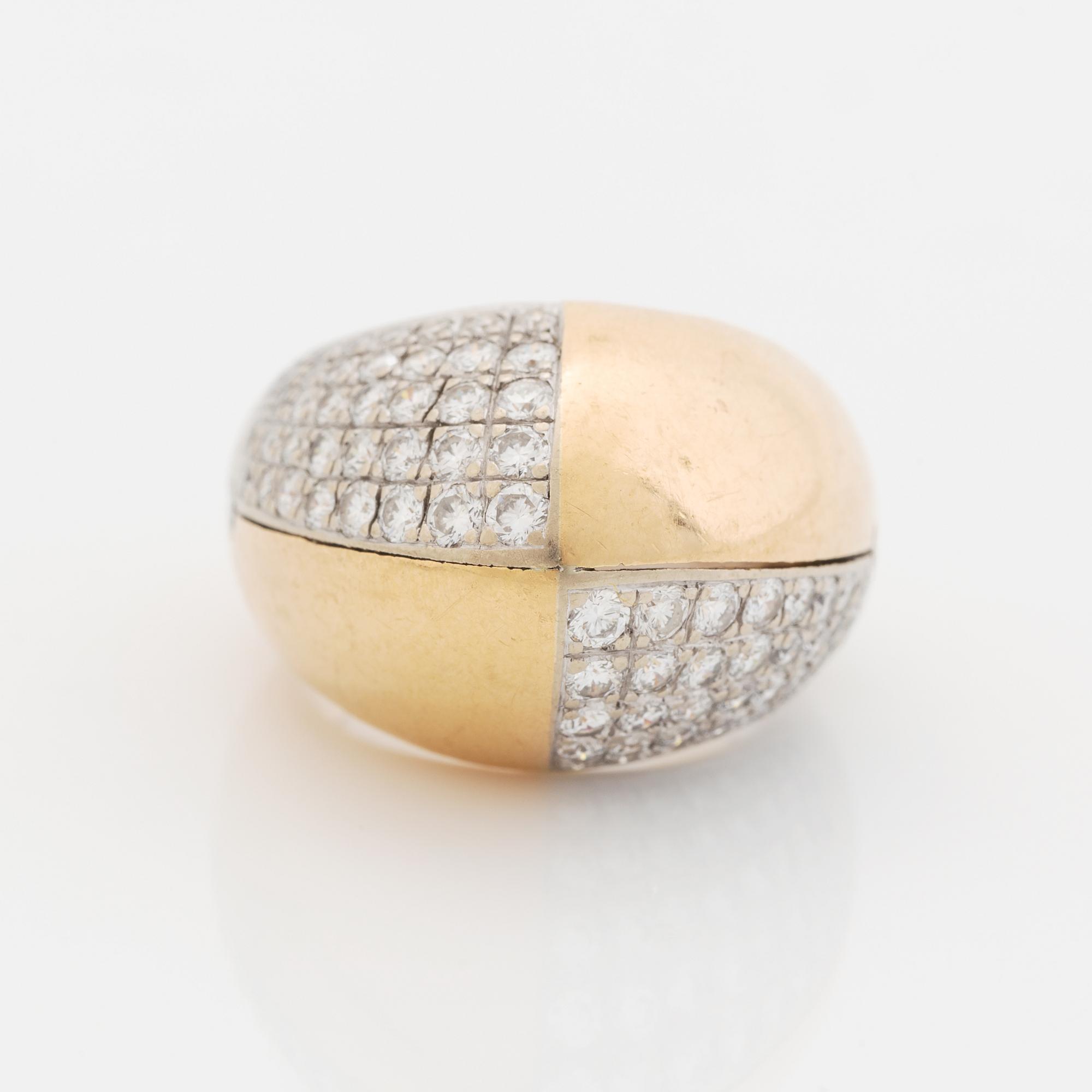 A Paul Binder ring in 18K gold set with round brilliant-cut diamonds.