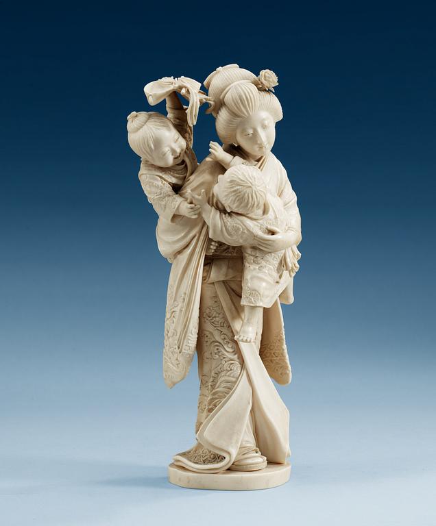 A Japanese ivory figure of a mother with two children, Meiji (1867-1912). Signed.