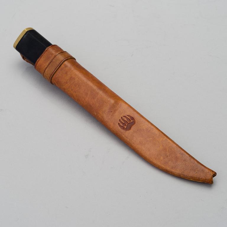 A Finnish puukko knife in stainless steel, nylon and brass designed by Tapio Wirkkala, Hackman Finland.