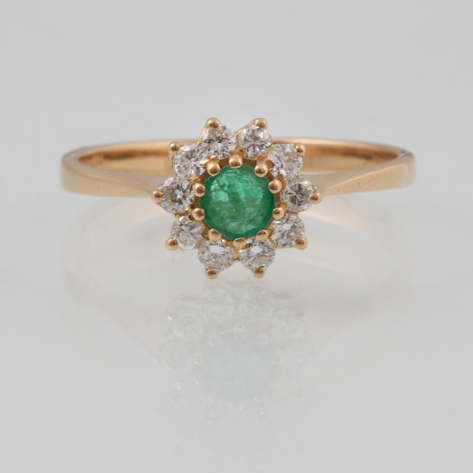 RING, 18K guld med fasettslipad smaragd samt 10 briljantslipade diamanter ca 0.10 ct,  importstämplad. Vikt 2,4 gram.