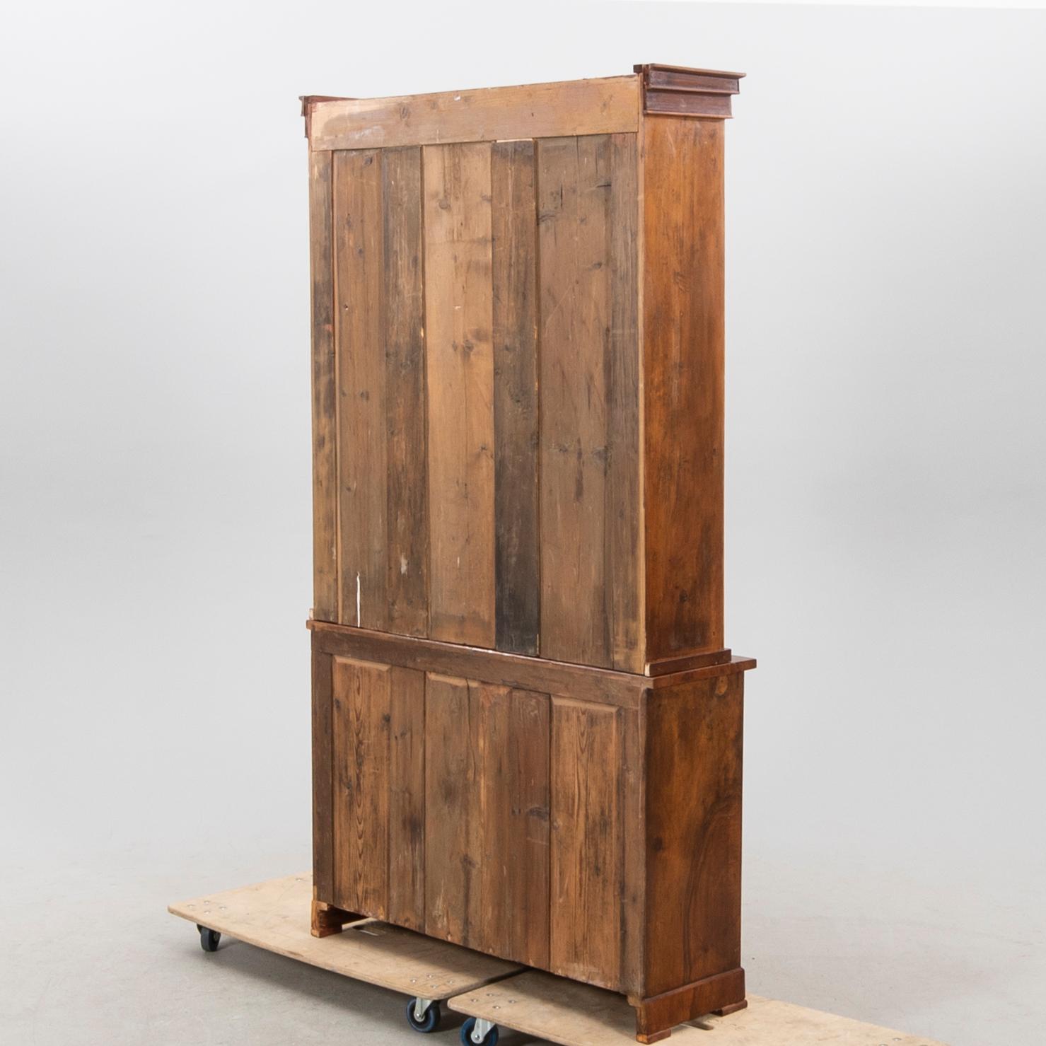 A stained walnut cabinet from the first half of the 20th century.
