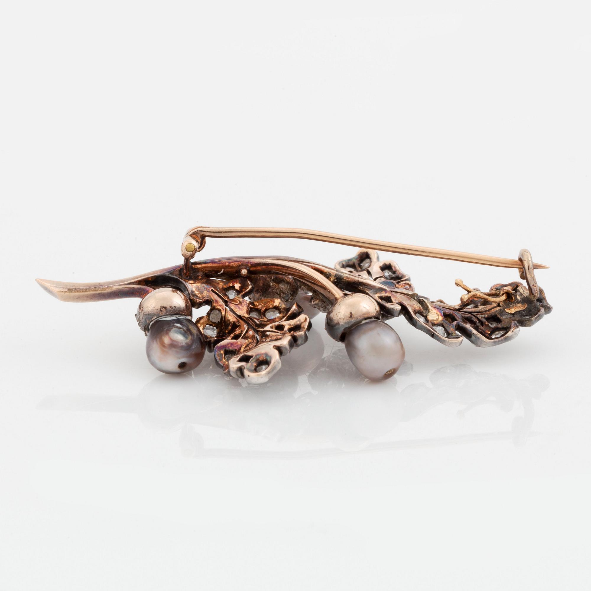 A silver and gold brooch set with pearls and rose-cut diamonds.
