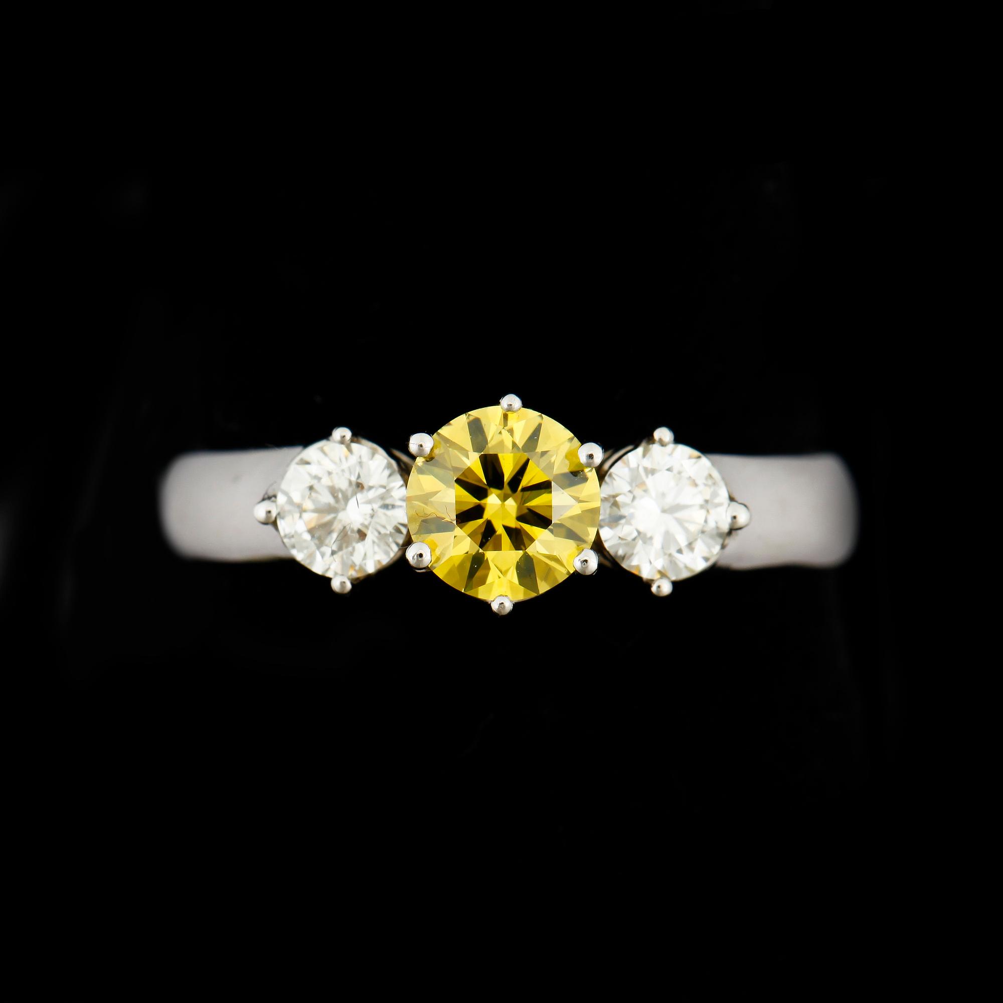 RING, 18k vitguld med briljantslipade diamanter, mittsten gul diamant ca0,55ct och två st tot ca0,41ct. Vikt 3,8g.