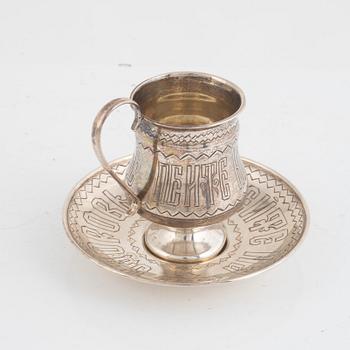 A silver teacup and saucer, possibly Pavel Perepyekin, Moscow 1885 and silver tea glass holder, 1891.