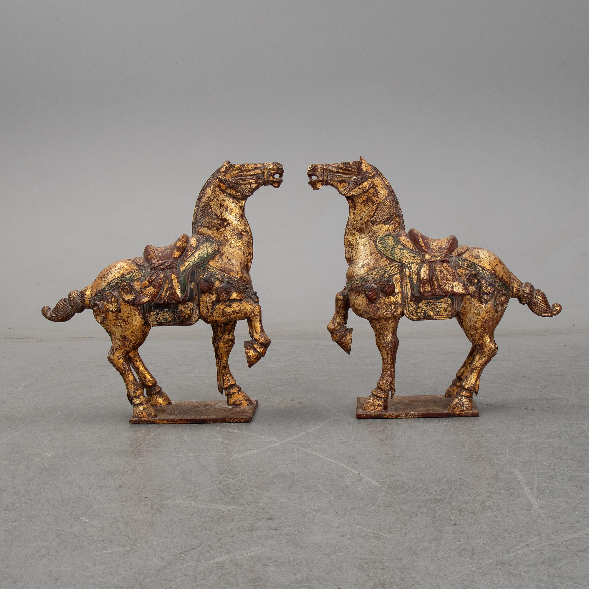A pair of large Chinese wooden and gilt sculpture of horses, first half of the 20th century.