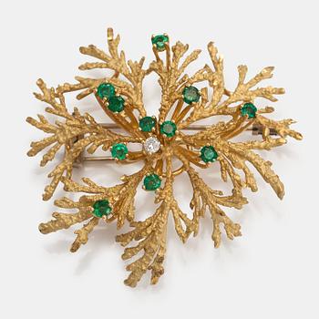 An 18K gold brooch with a diamond ca. 0.06 ct and emeralds.