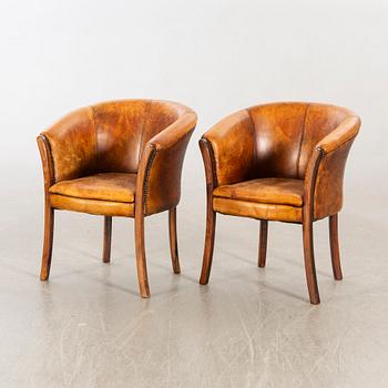 A pair of leather armchairs later part of the 20th century.