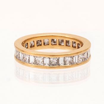 An 18K gold eternity ring set with baguette and princess cut diamonds by Hartmann's Denmark.