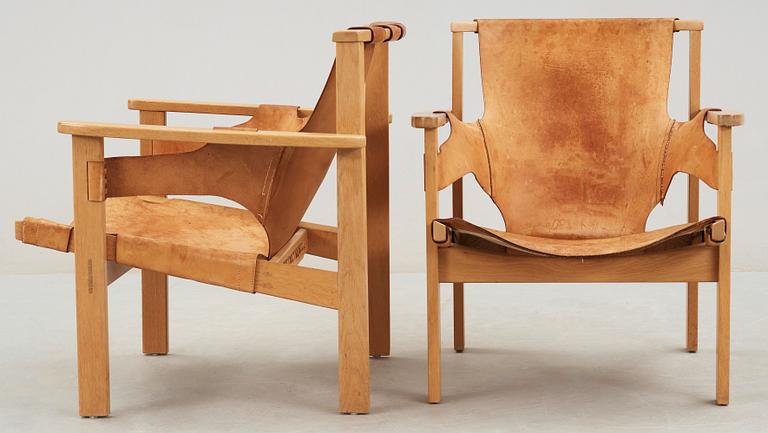 A pair of Carl-Axel Acking oak and beige leather armchairs, 'Trienna', Sweden 1950's-60's.