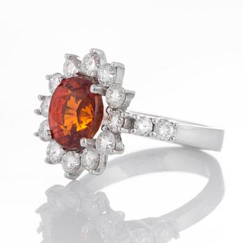Ring med en fasettslipad spessartingranat samt runda briljantslipade diamanter.